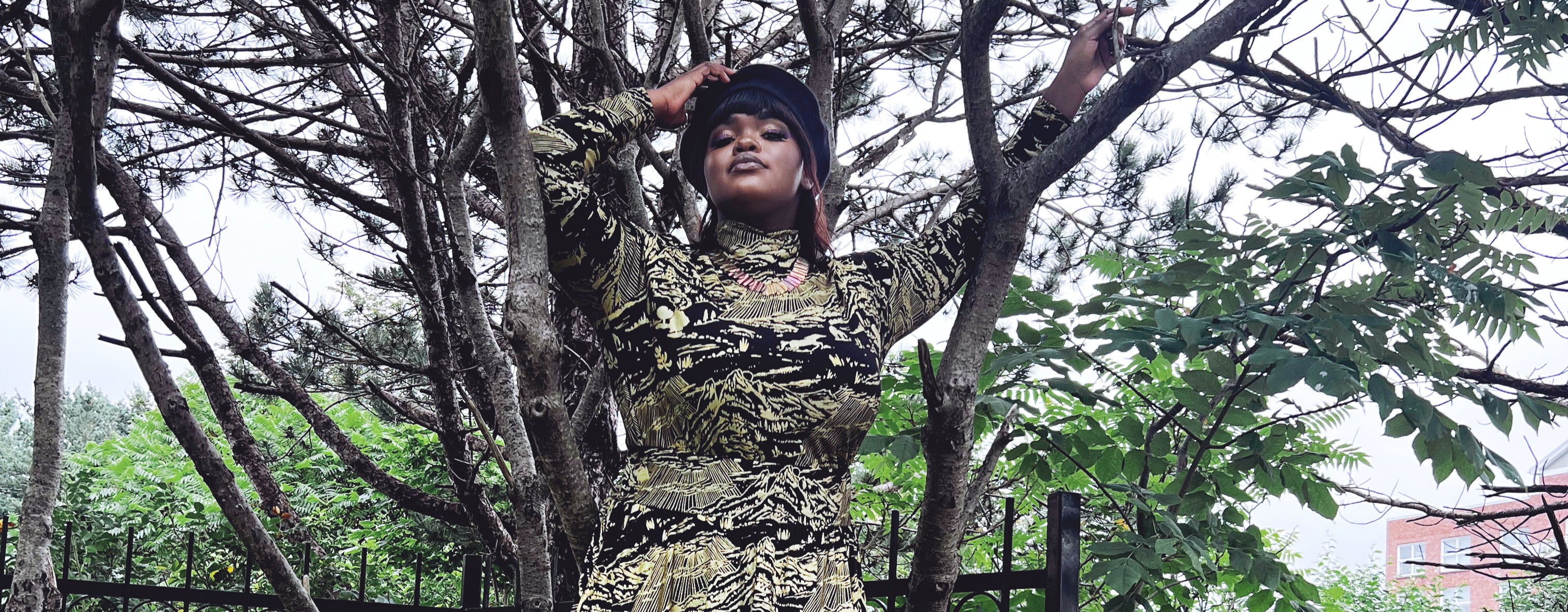 woman standing wearing gold and black thief and bandit turtleneck and skirt