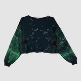 Green and black sweater with star pattern on a light gray background