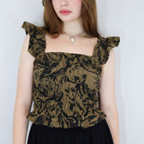 Model wearing a black and brown shirred flutter sleeve cotton blouse featuring a fox print paired with a matching black skirt.