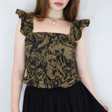 Model wearing a black and brown shirred flutter sleeve cotton blouse featuring a fox print paired with a matching black skirt.