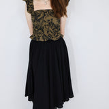 Model wearing a black and brown shirred flutter sleeve cotton blouse featuring a fox print paired with a matching black skirt.