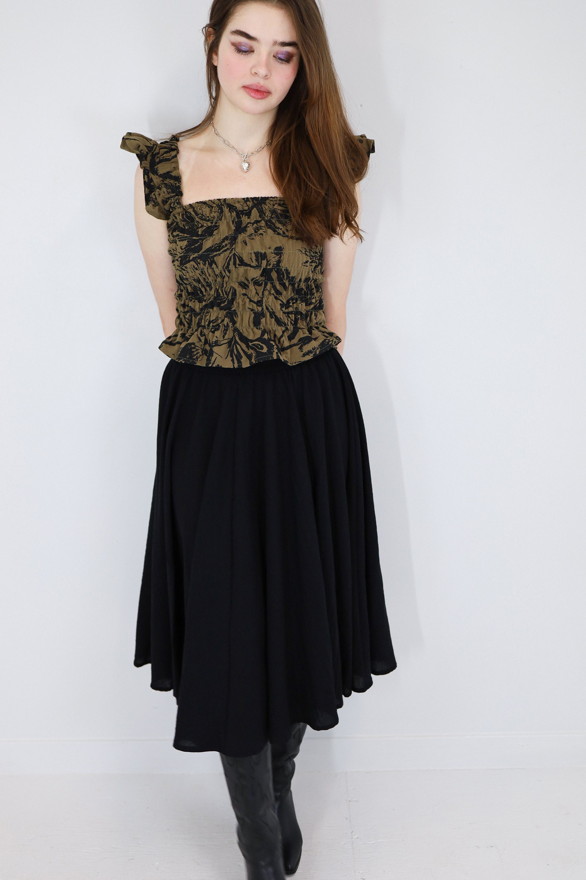 Model wearing a black and brown shirred flutter sleeve cotton blouse featuring a fox print paired with a matching black skirt.