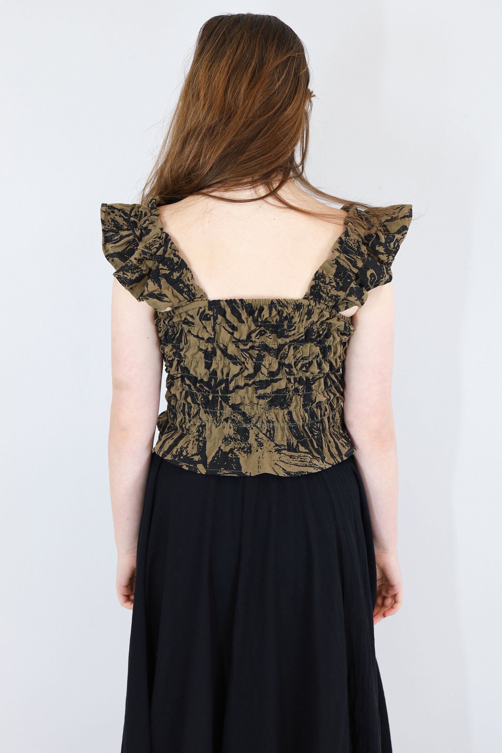 Model wearing a black and brown shirred flutter sleeve cotton blouse featuring a fox print paired with a matching black skirt.