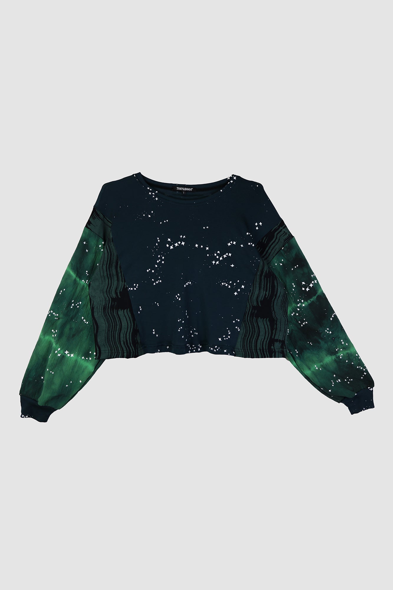 Green and black sweater with star pattern on a light gray background