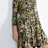 Model wearing a gold on black mushroom dress in a fit and flare twirl styled with black cowboy boots.
