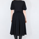 Model wearing a black twirl circle skirt facing back