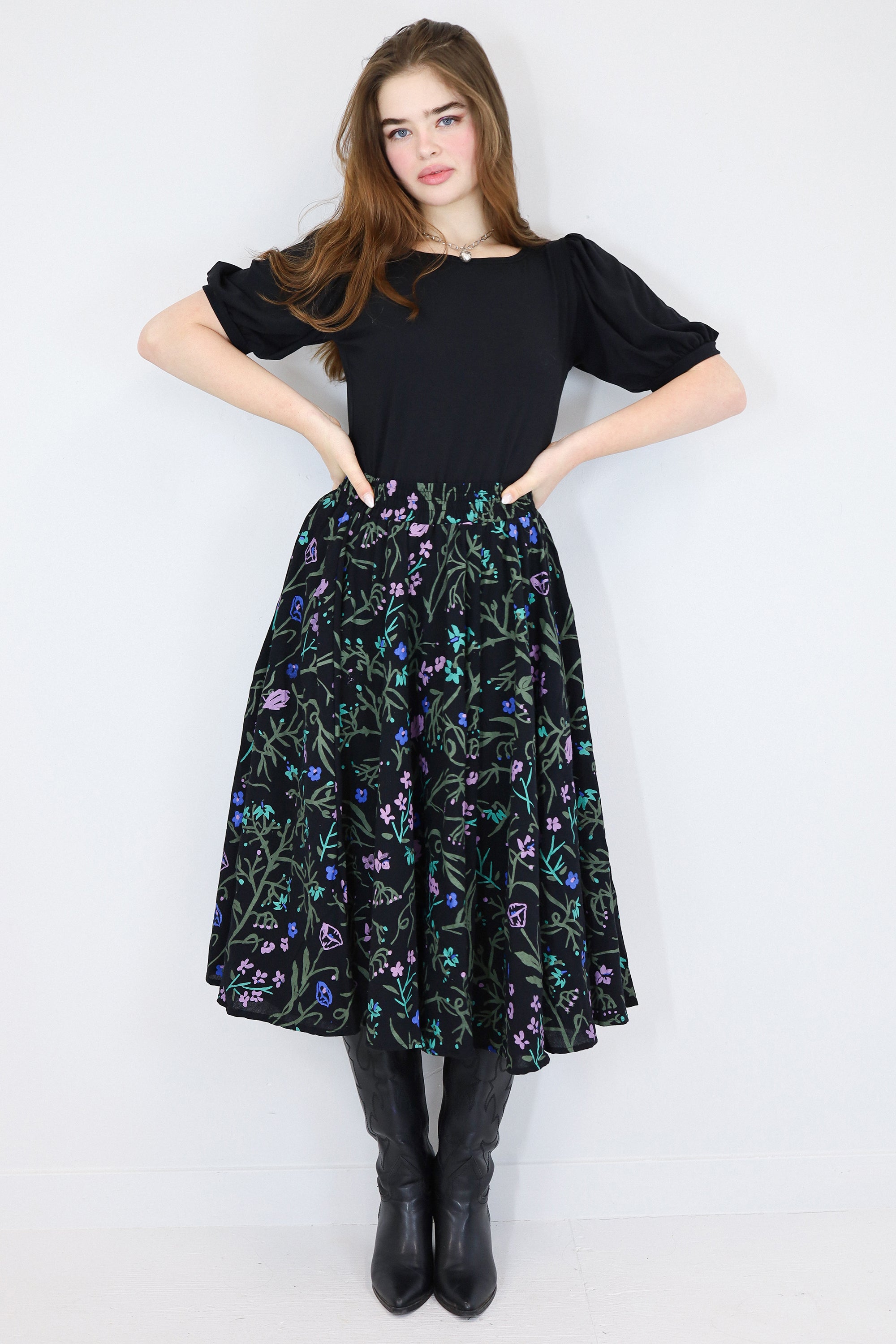 Model wearing a black floral twirl circle skirt facing forward