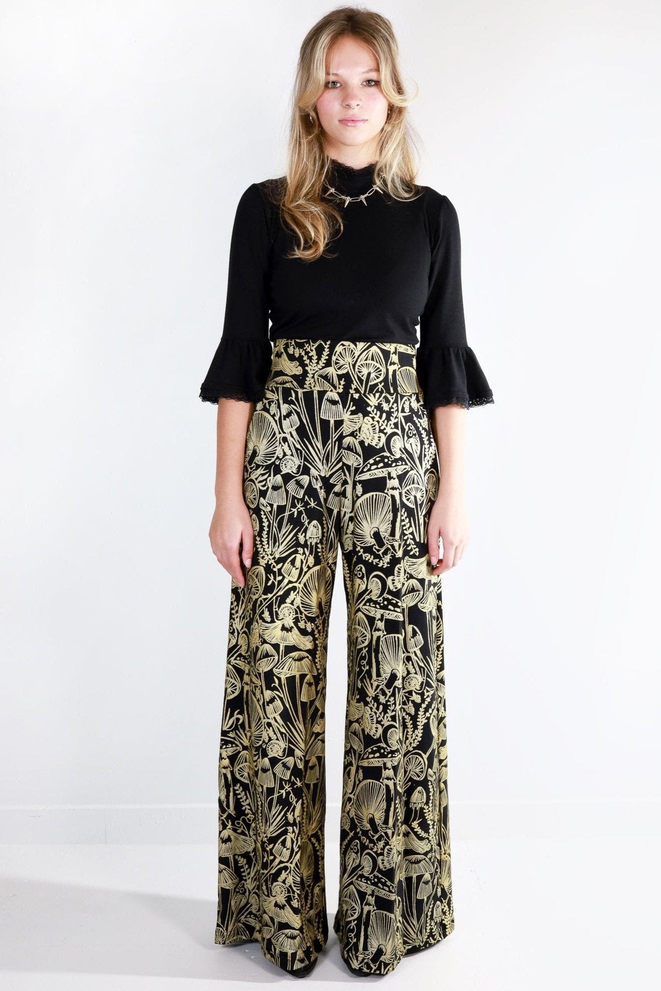Model wearing mushroom print wide leg pants facing forward 