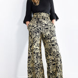 Model wearing mushroom print wide leg flowy pants facing forward 