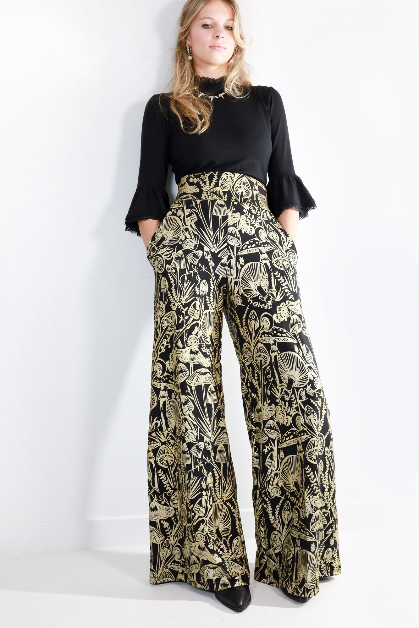 Model wearing mushroom print wide leg flowy pants facing forward 